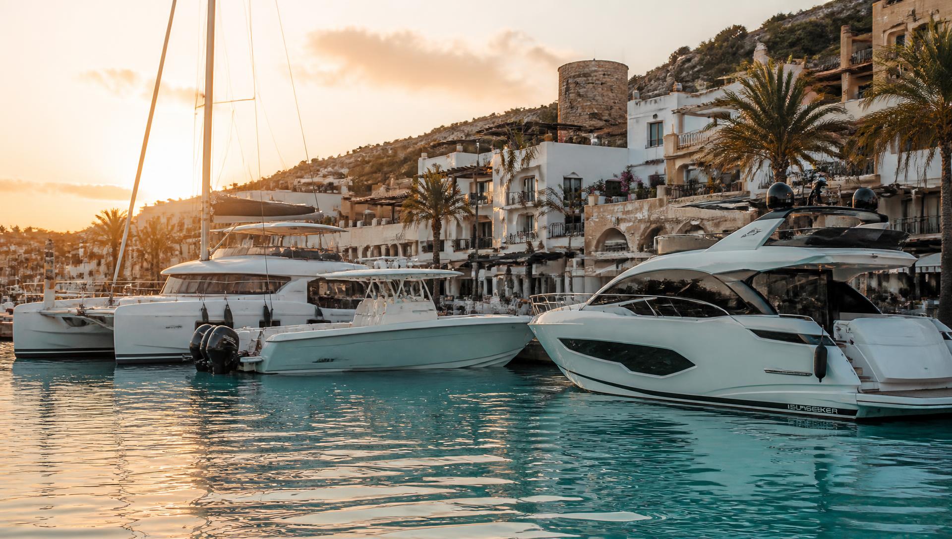 Marina with motor yachts, sailboats and sport boats at golden hour
